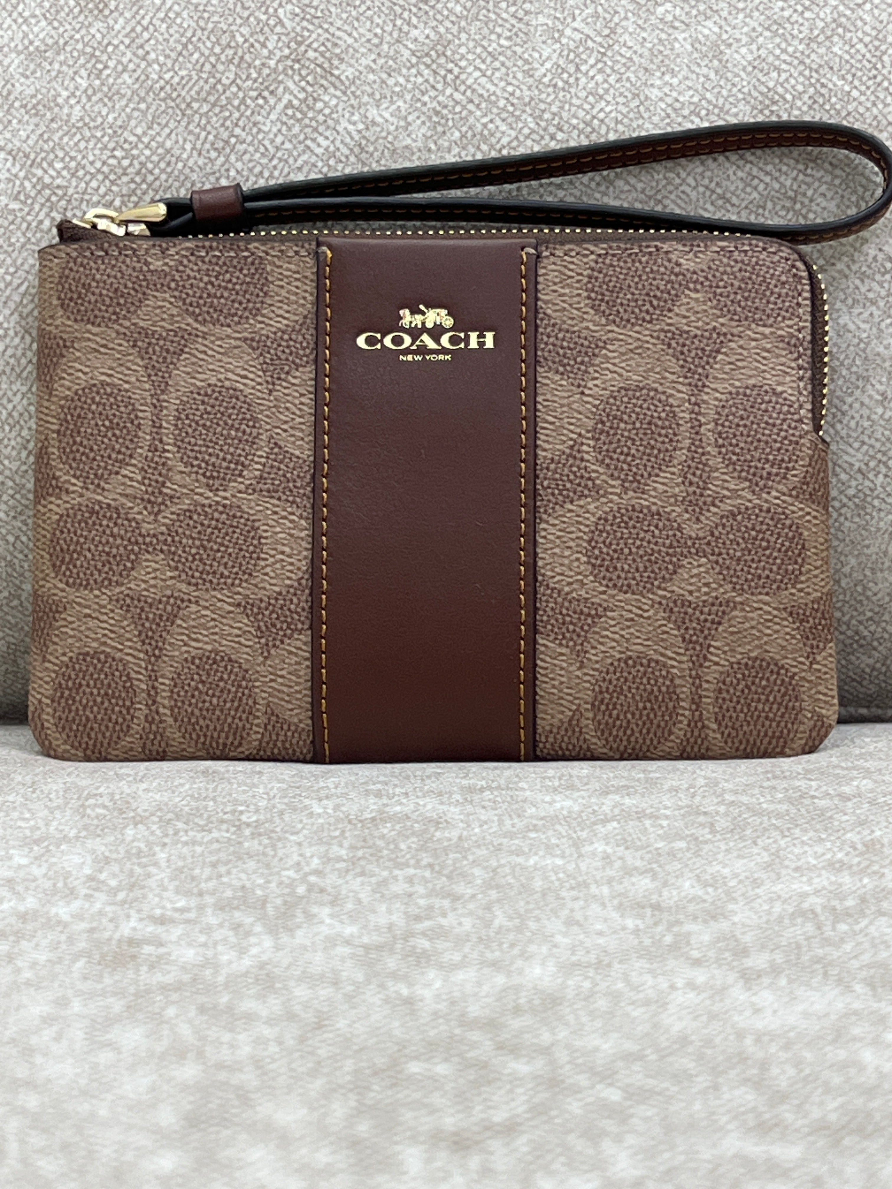 Coach Corner Zip Wristlet in signature canvas with a brown leather stripe
