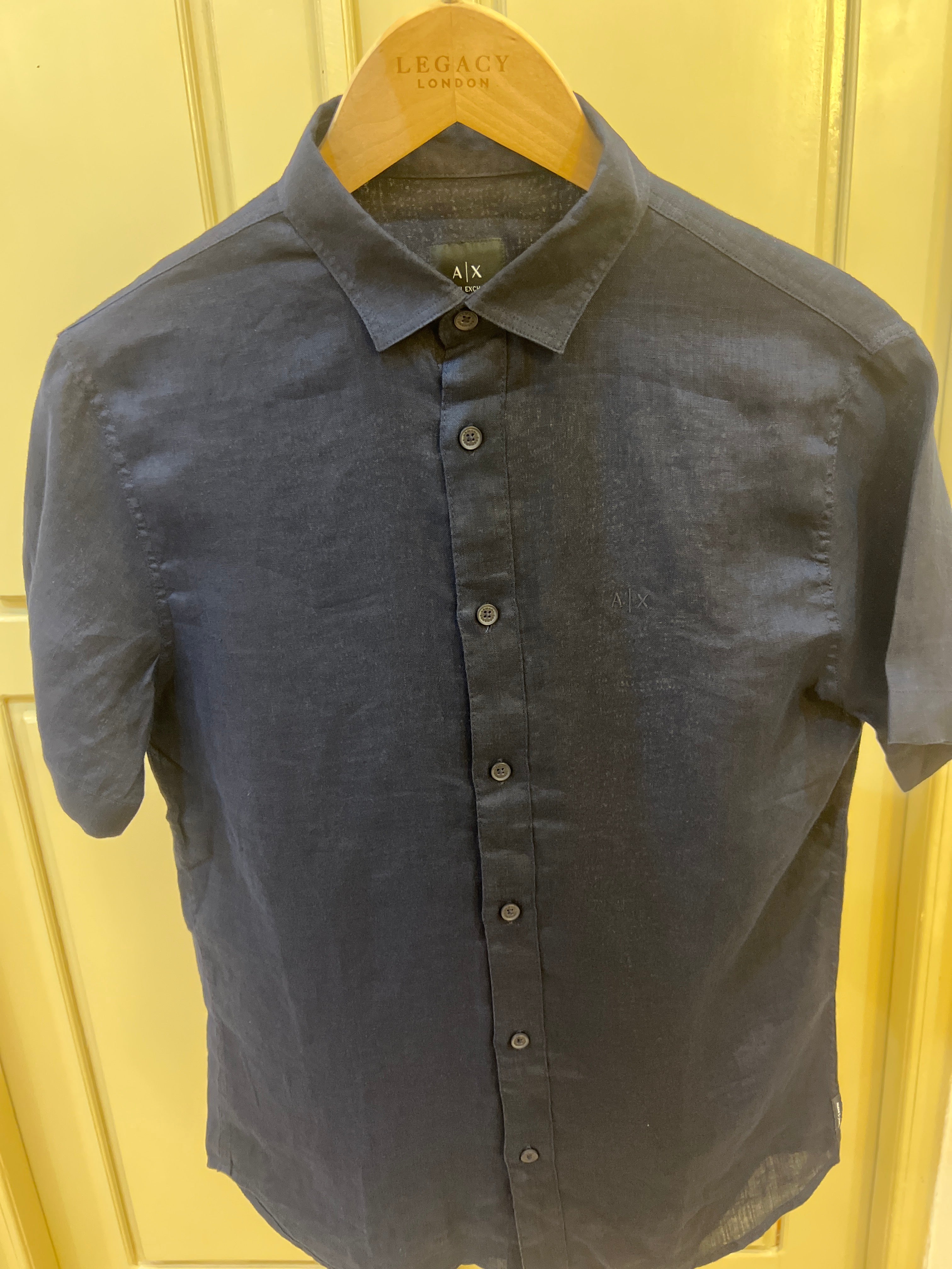 Armani Exchange shirt features a dark navy blue color and is made from a lightweight material