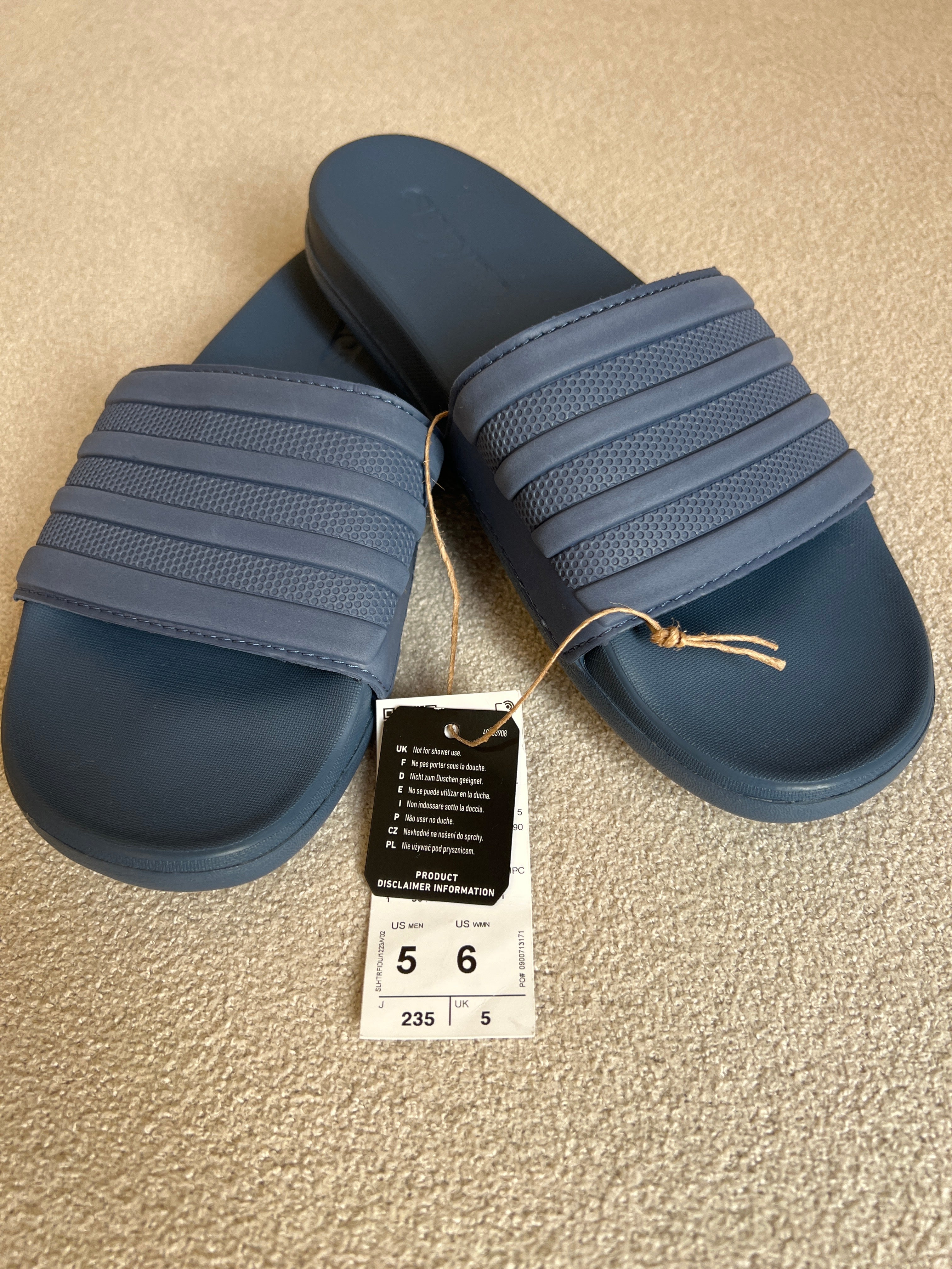Adidas Adilette Comfort Slides, a lightweight slip-on sandal featuring a contoured footbed for cushioning and 3-Stripes branding