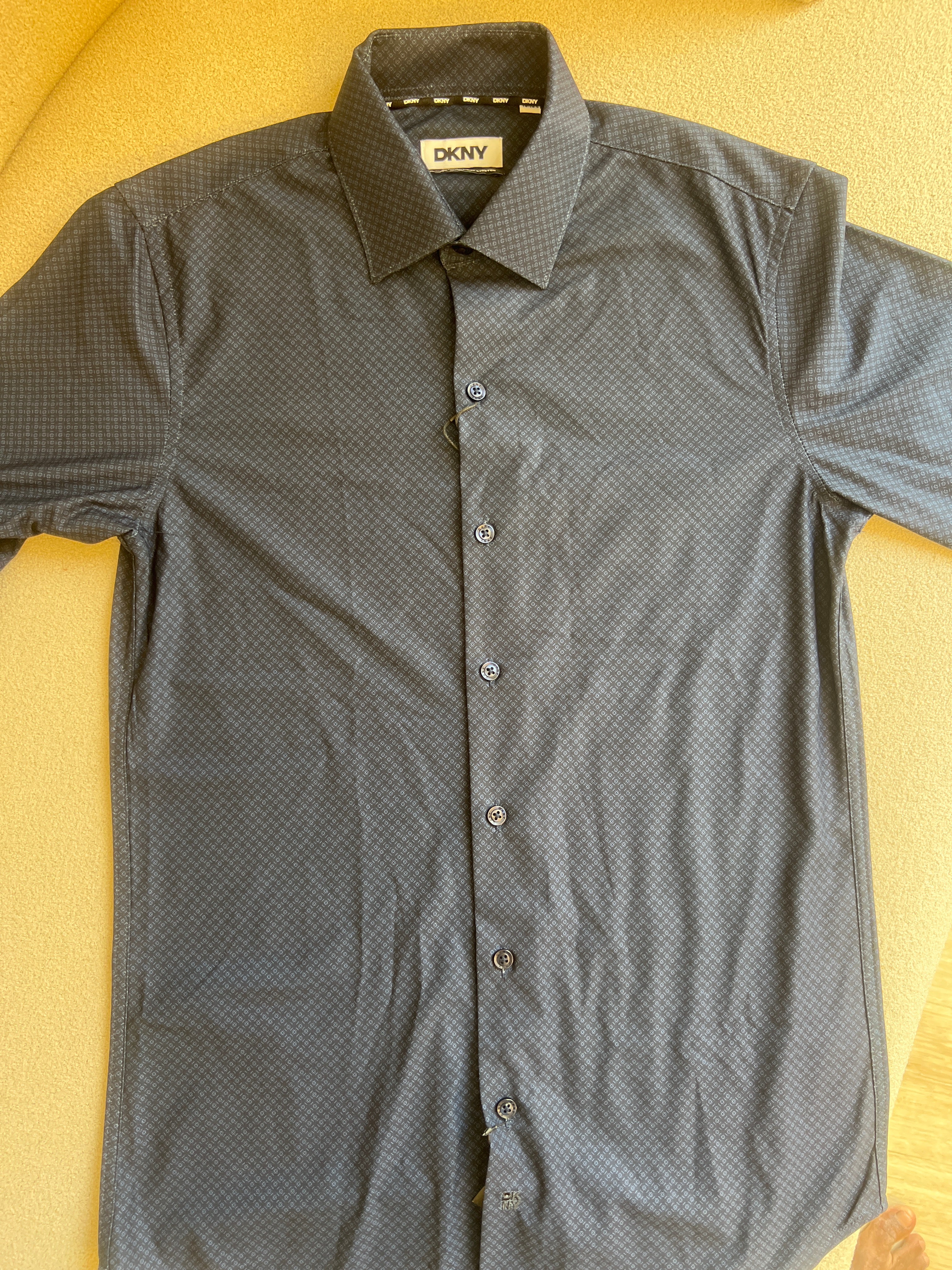 DKNY men's dress shirt is featured in a deep navy blue with a subtle textured pattern