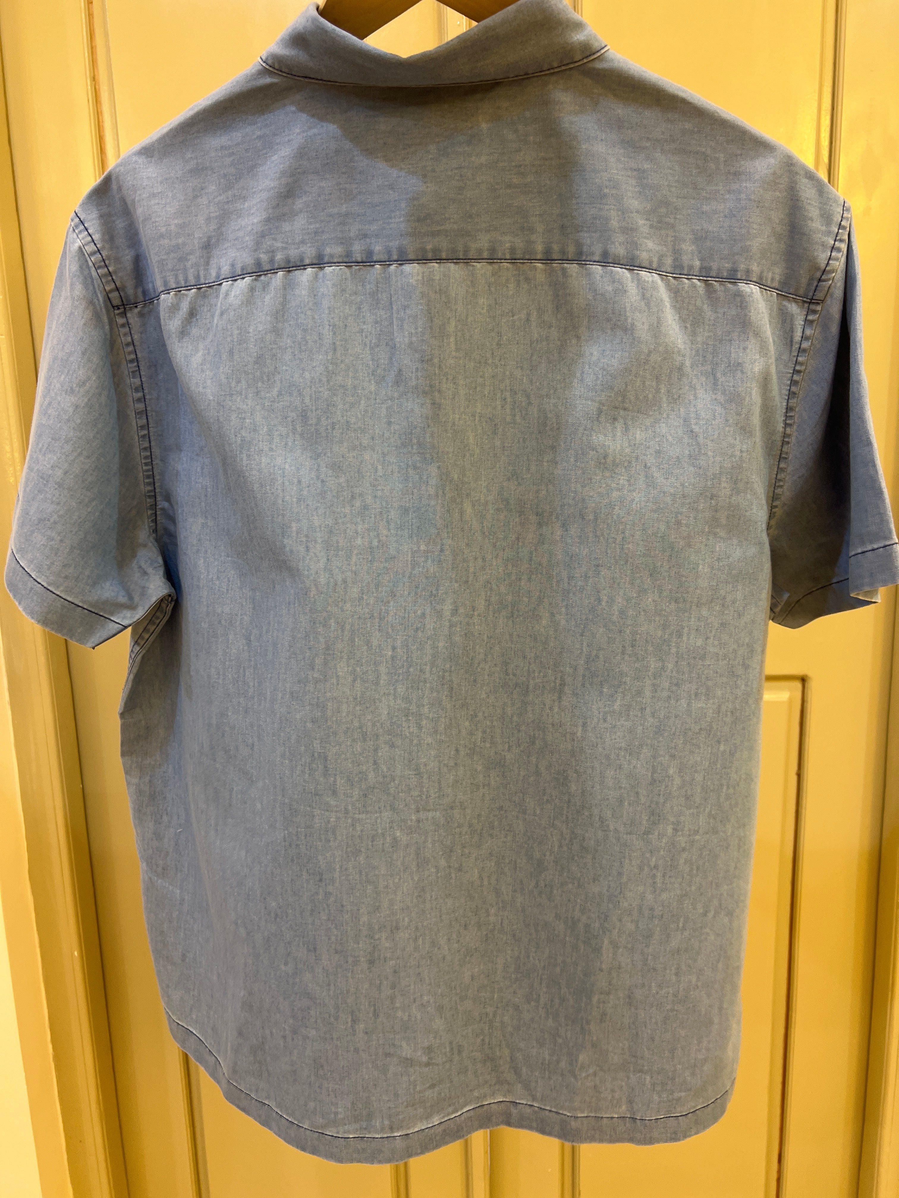 DKNY light blue shirt features two chest patch pockets and a button-up front