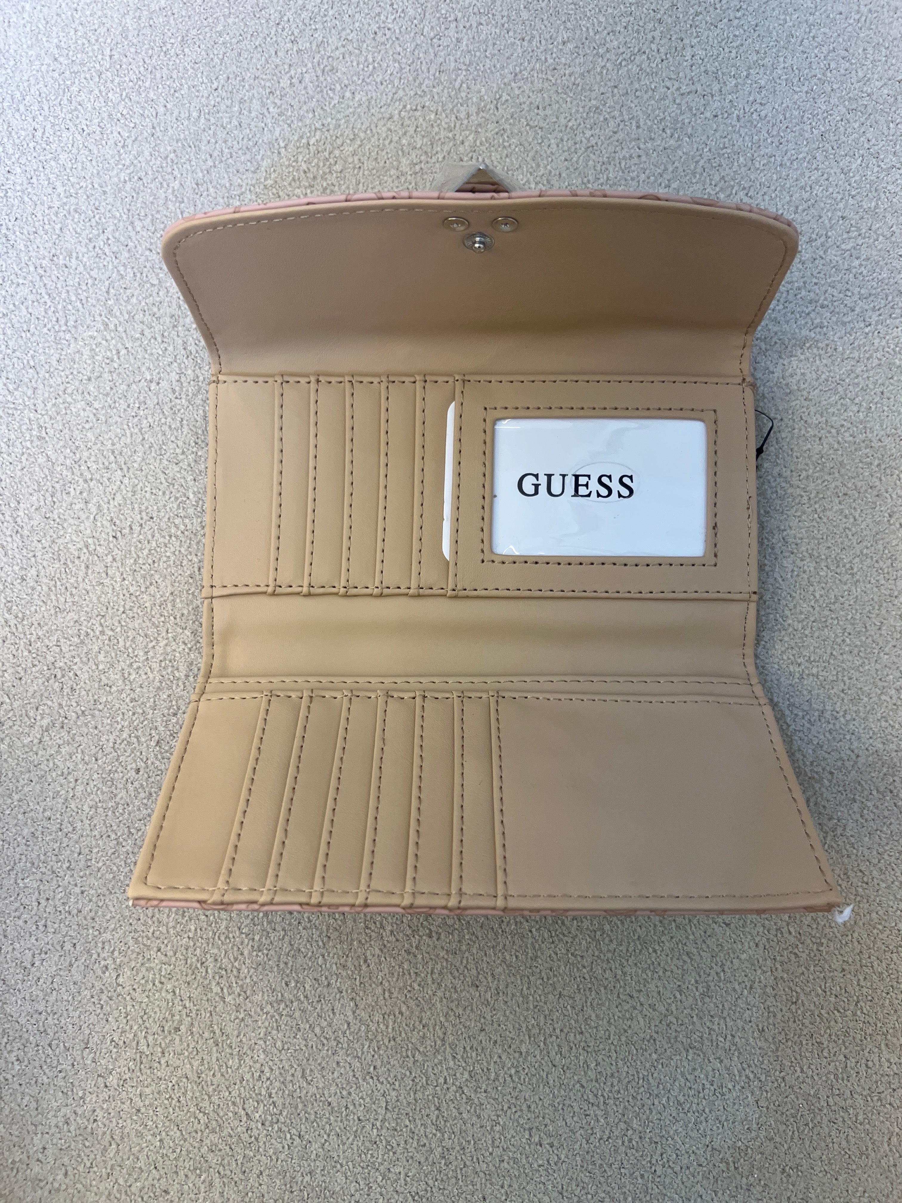 Guess Viviette tri-fold wallet features a textured, light pink monogram exterior and a prominent triangular logo plaque