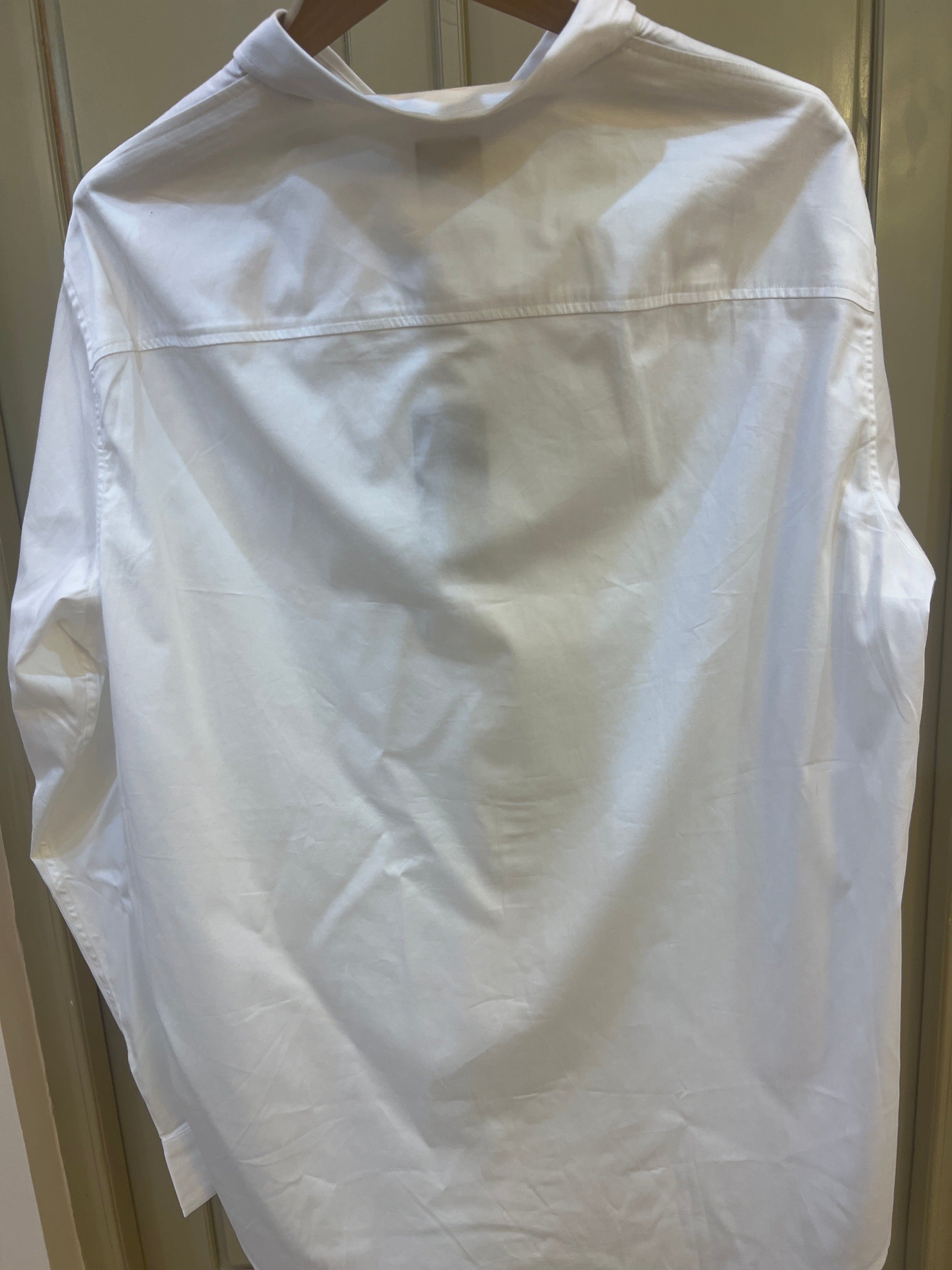 White long-sleeve Armani Exchange button-up shirt features a prominent cursive logo embroidered on the chest