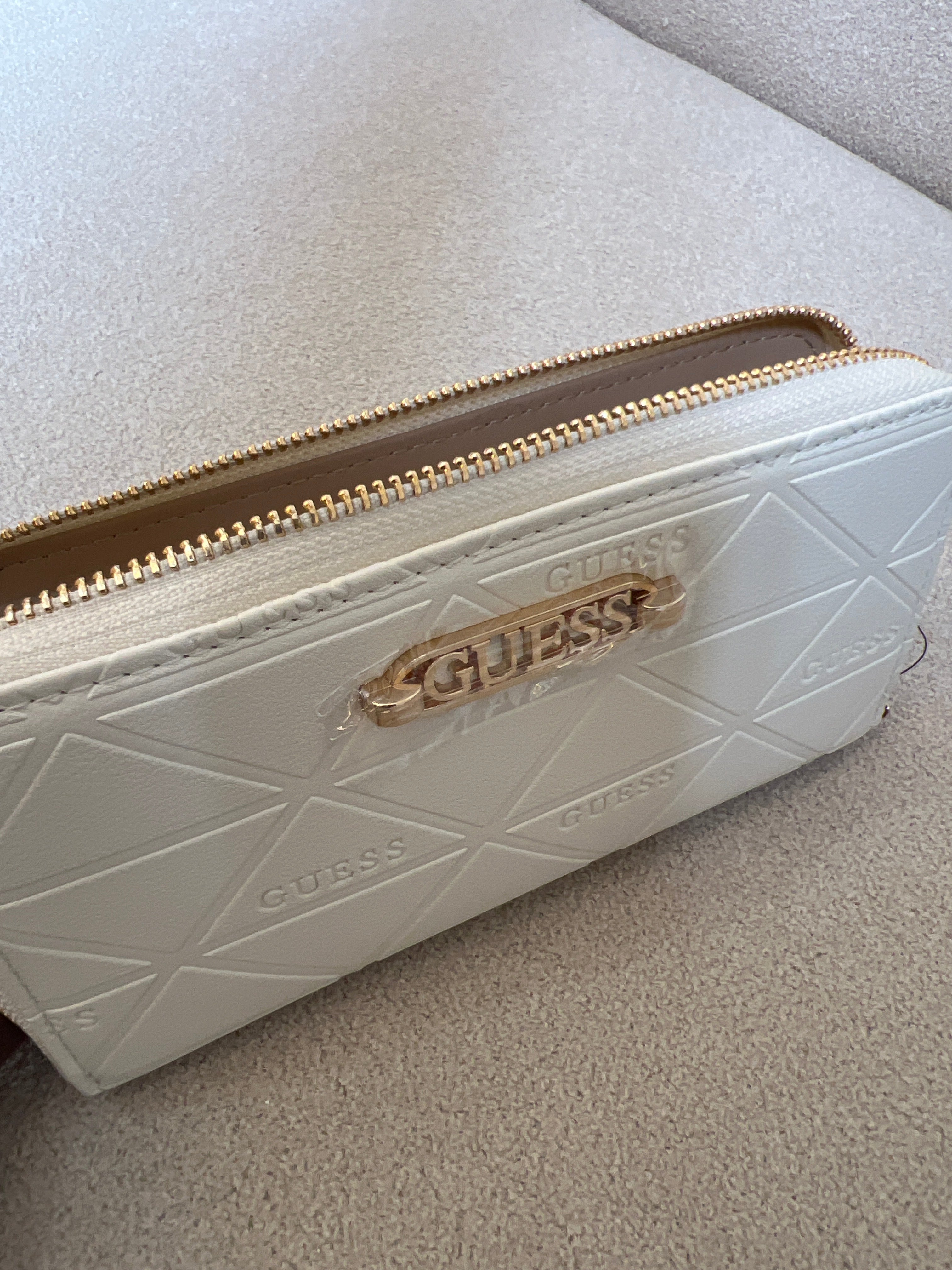 Guess wallet features a quilted triangular pattern and a prominent gold-toned brand logo on the front
