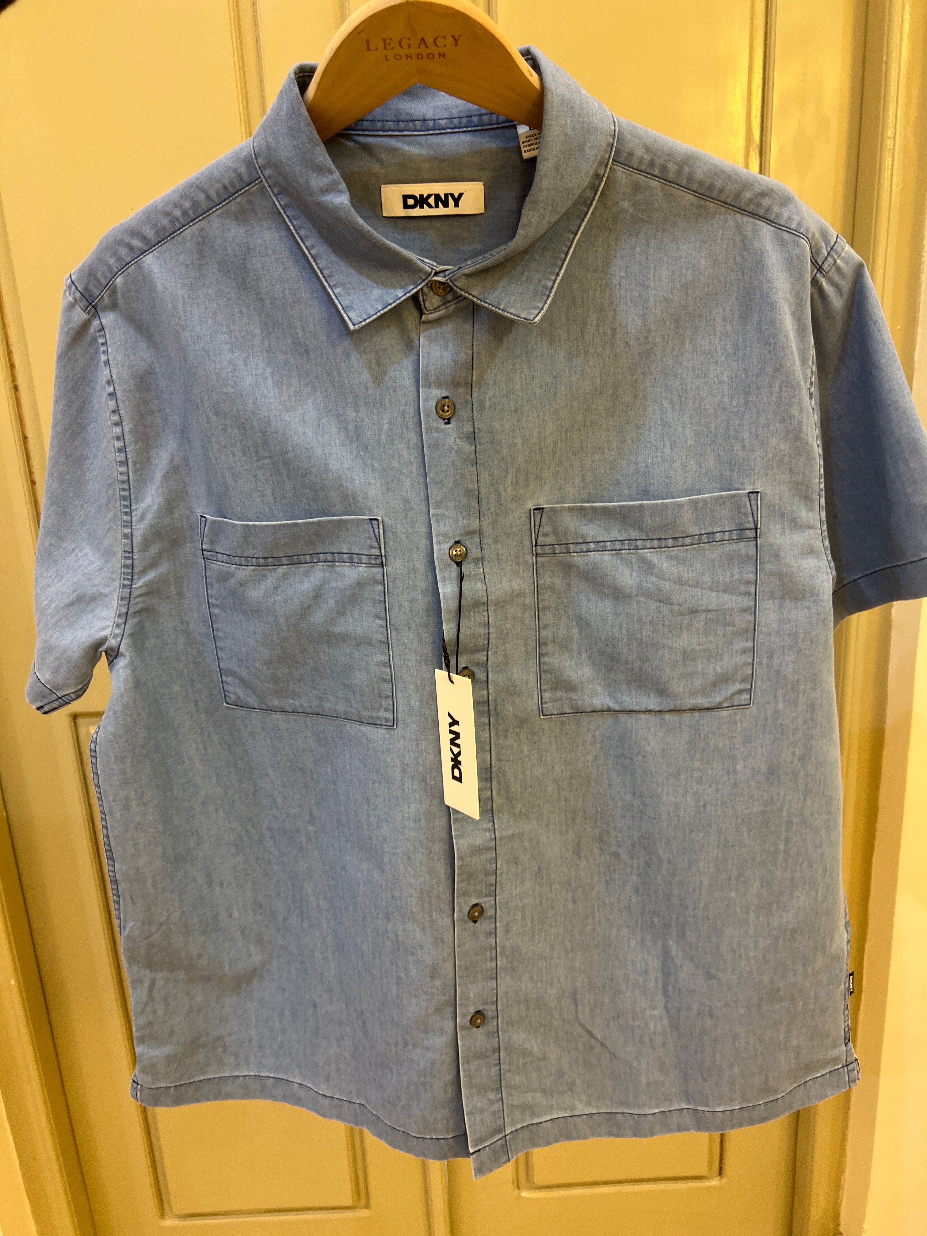 DKNY light blue shirt features two chest patch pockets and a button-up front