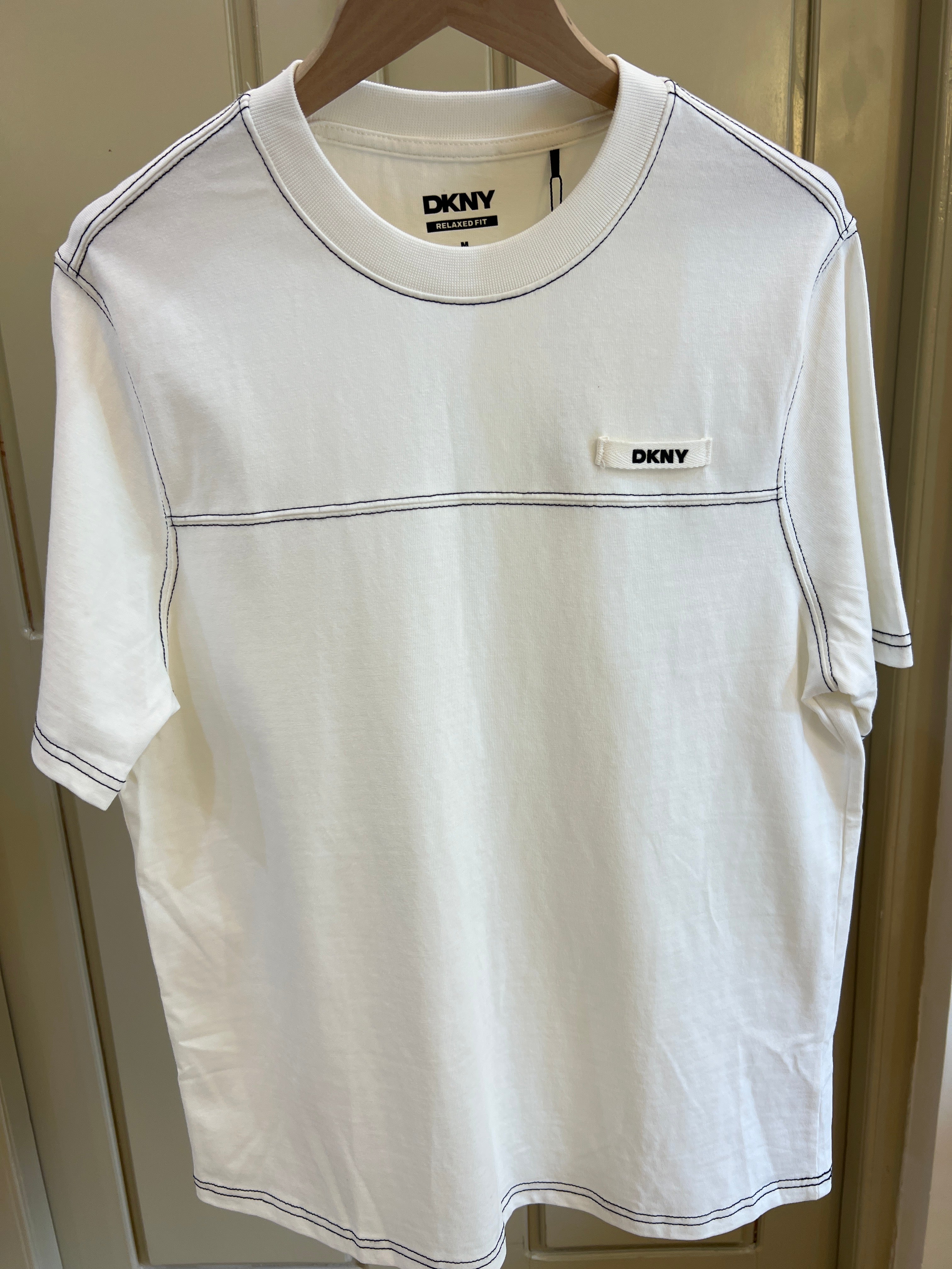 T-shirt by DKNY features contrasting black stitching details and a relaxed fit