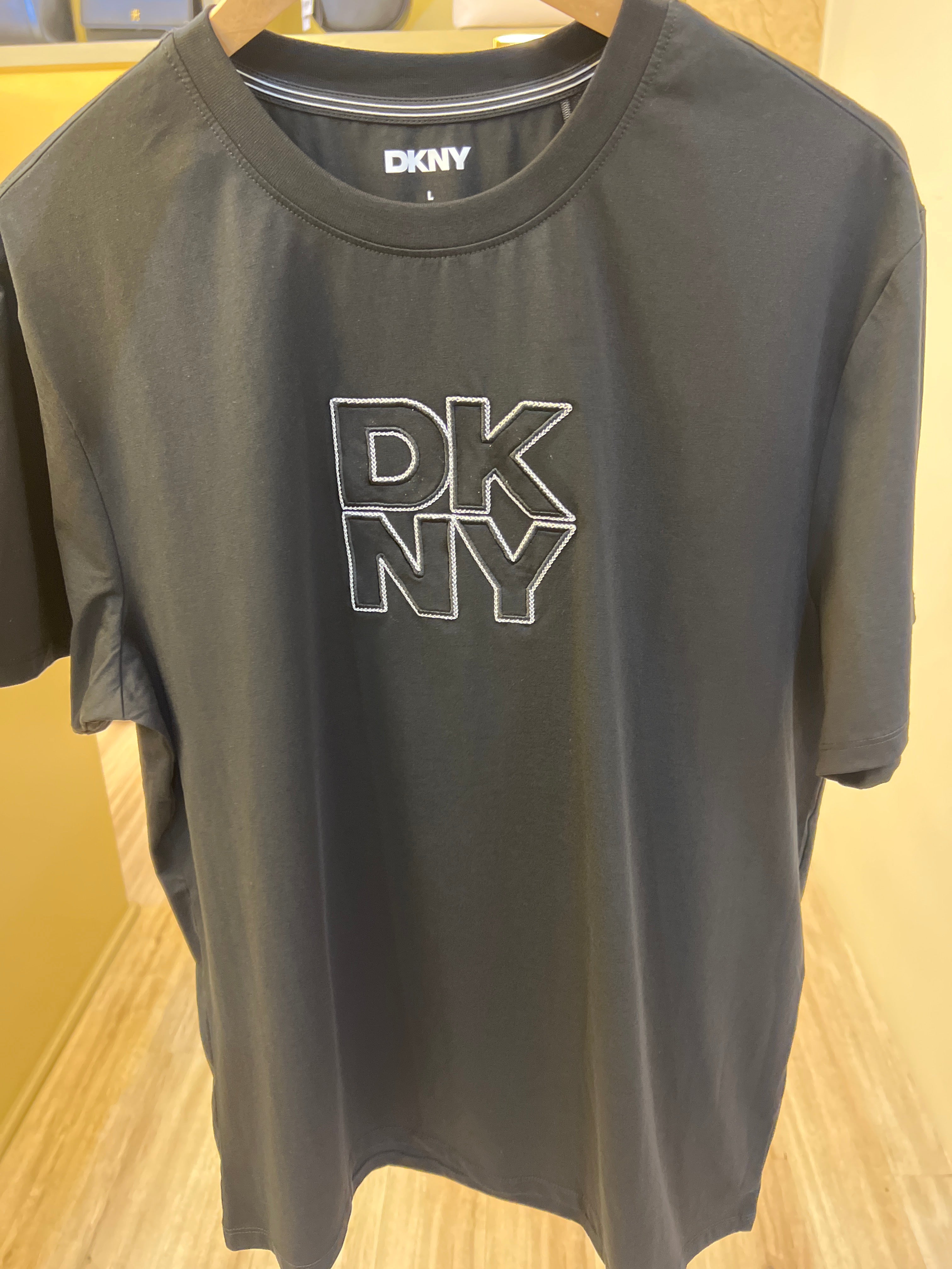 DKNY black crew neck t-shirt featuring a prominent white logo
