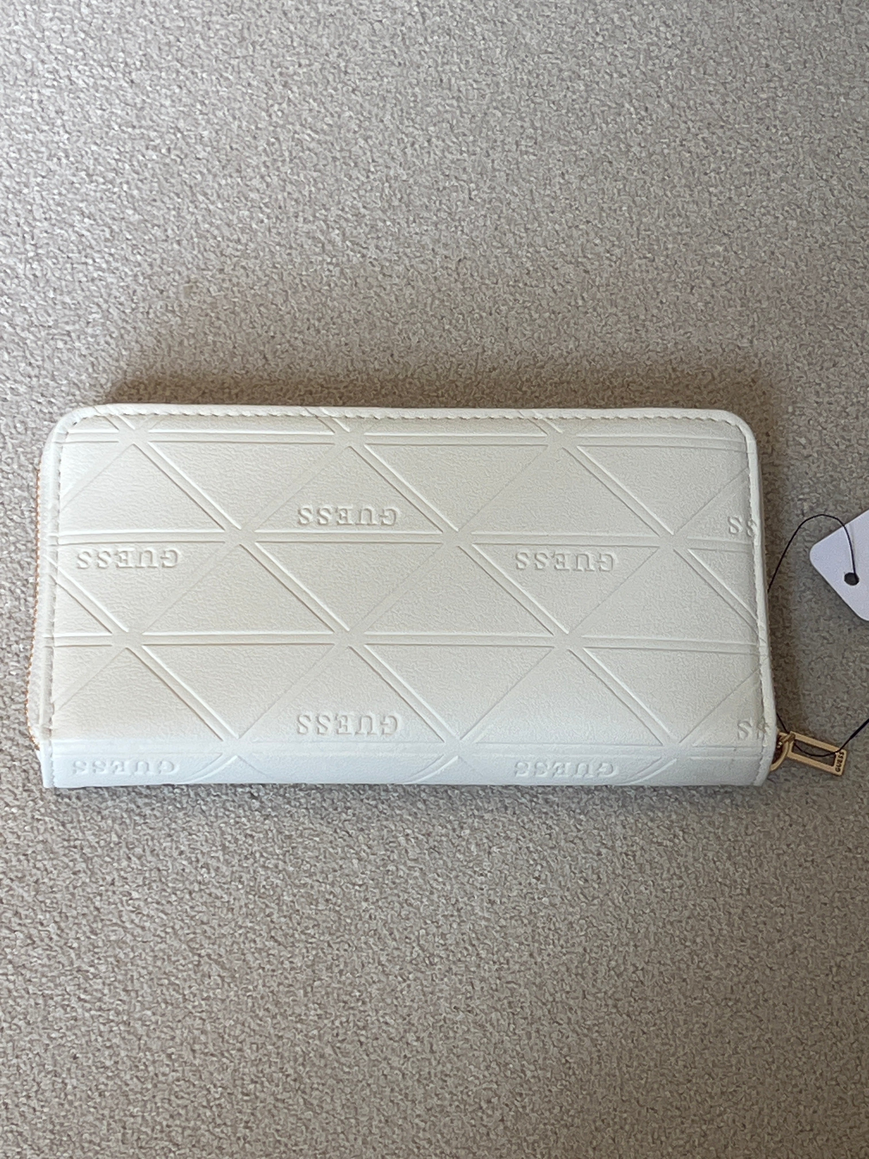 Guess wallet features a quilted triangular pattern and a prominent gold-toned brand logo on the front