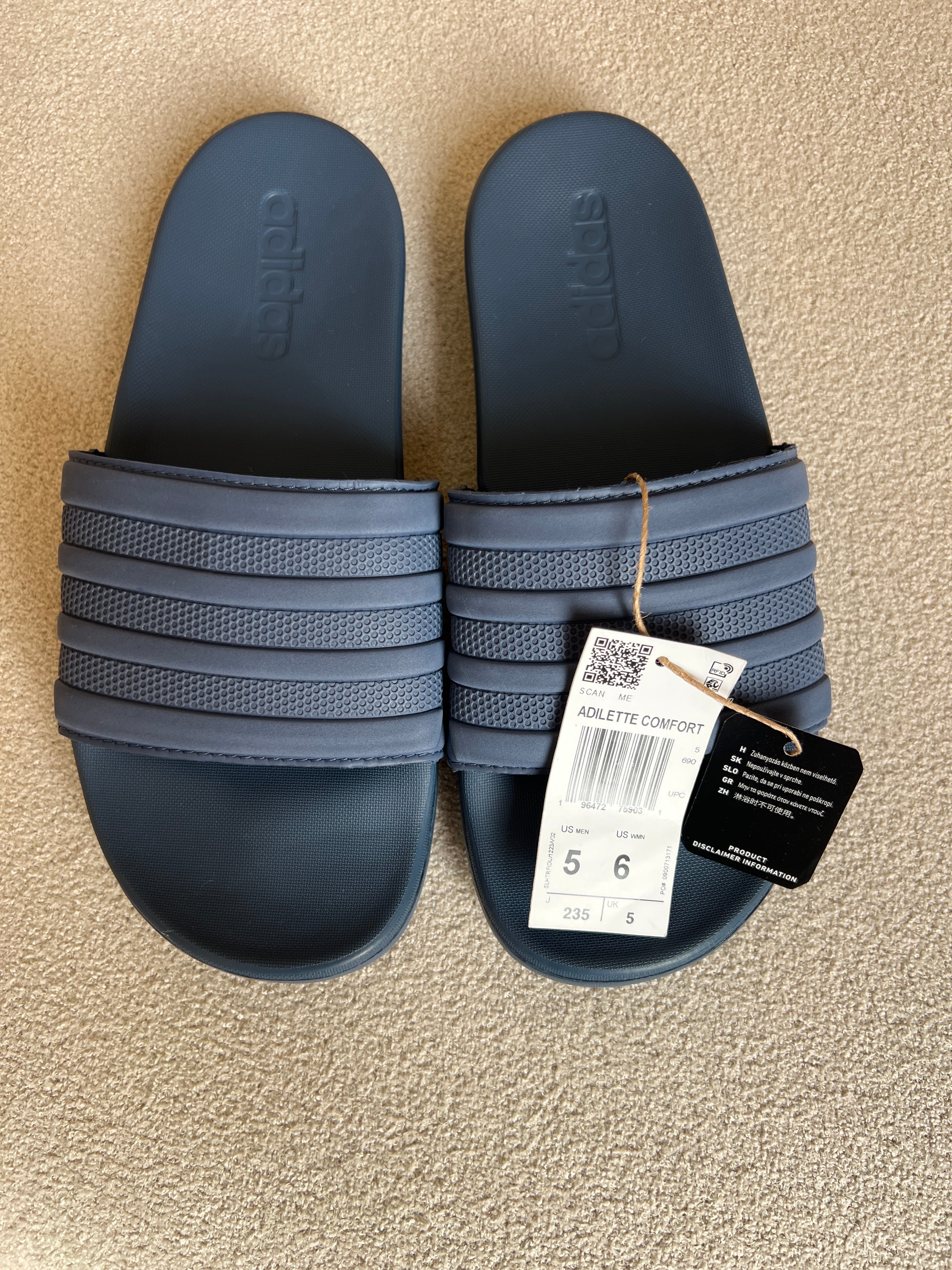 Adidas Adilette Comfort Slides, a lightweight slip-on sandal featuring a contoured footbed for cushioning and 3-Stripes branding
