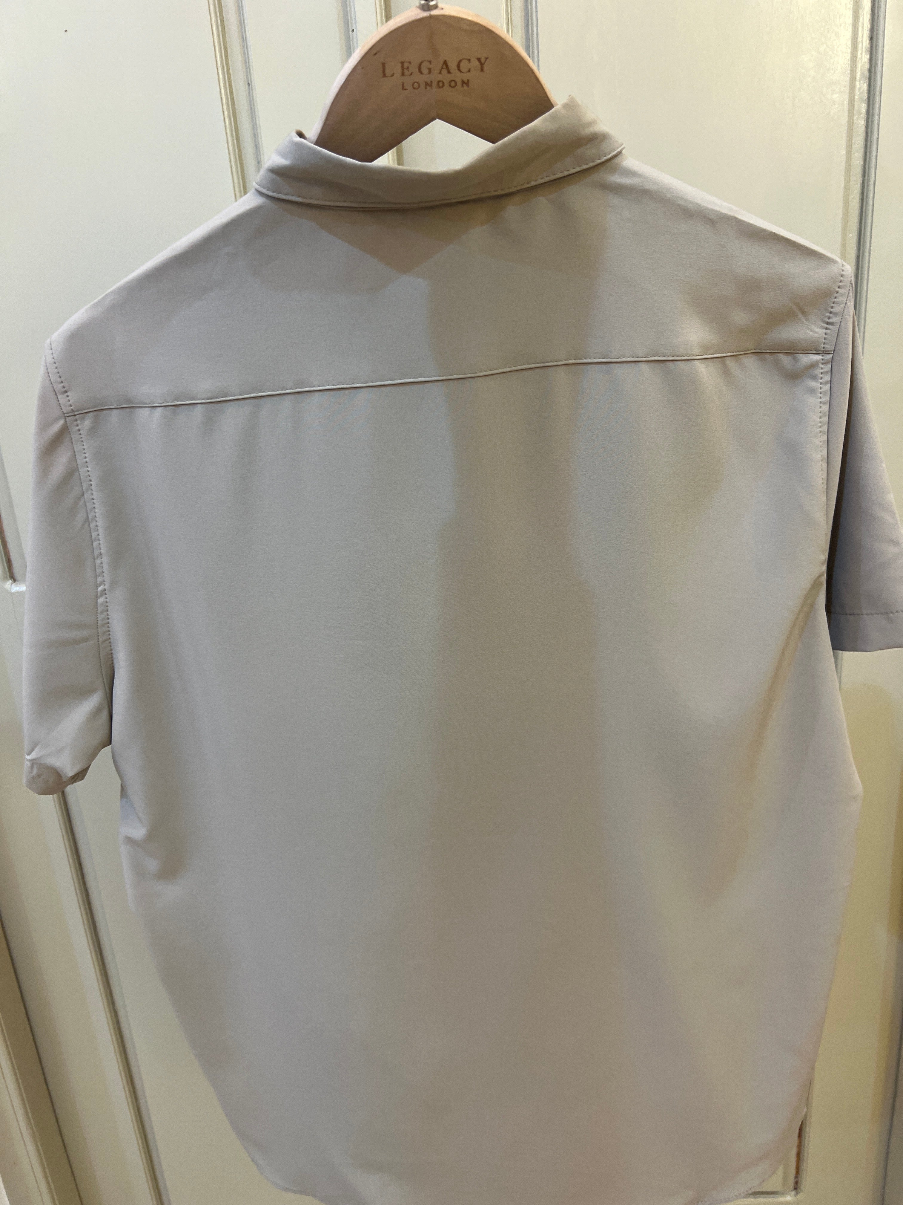 DKNY short-sleeve button-up shirt features a dark inner collar lining and a chest pocket