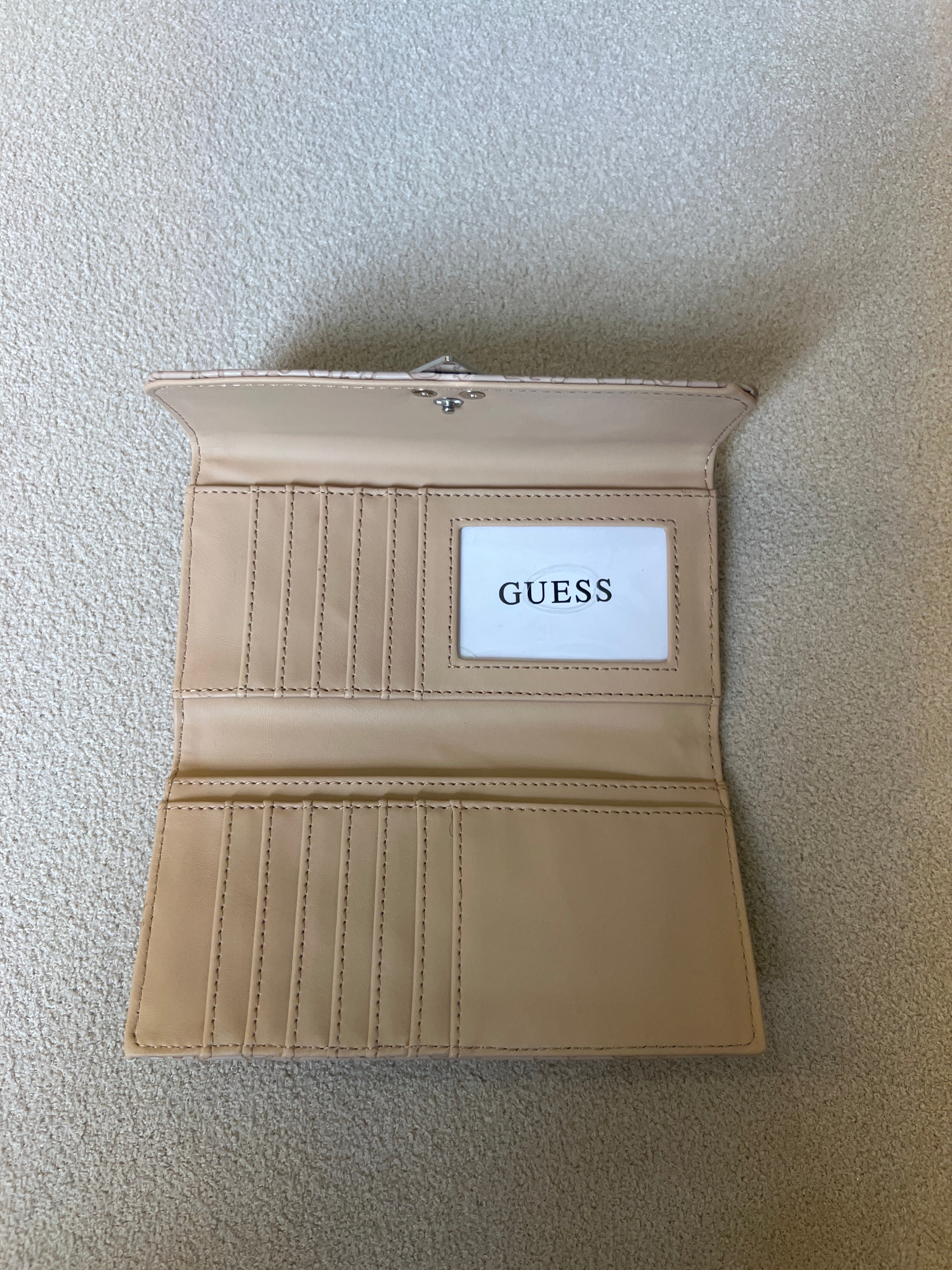 Guess "Viviette" SLG slim clutch wallet in a latte color with an all-over embossed logo pattern