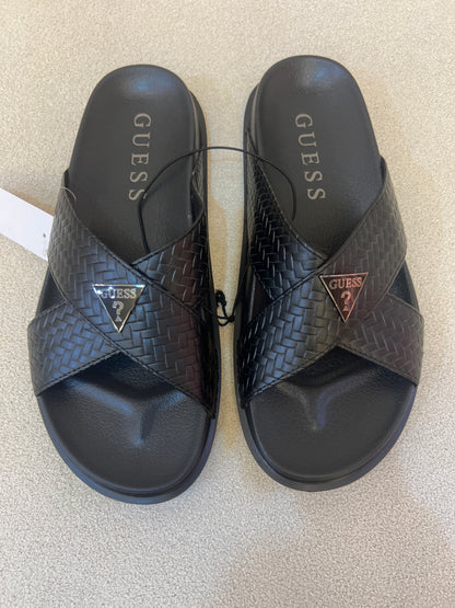GUESS black Banlin slide sandals featuring a woven design and a silver triangular logo