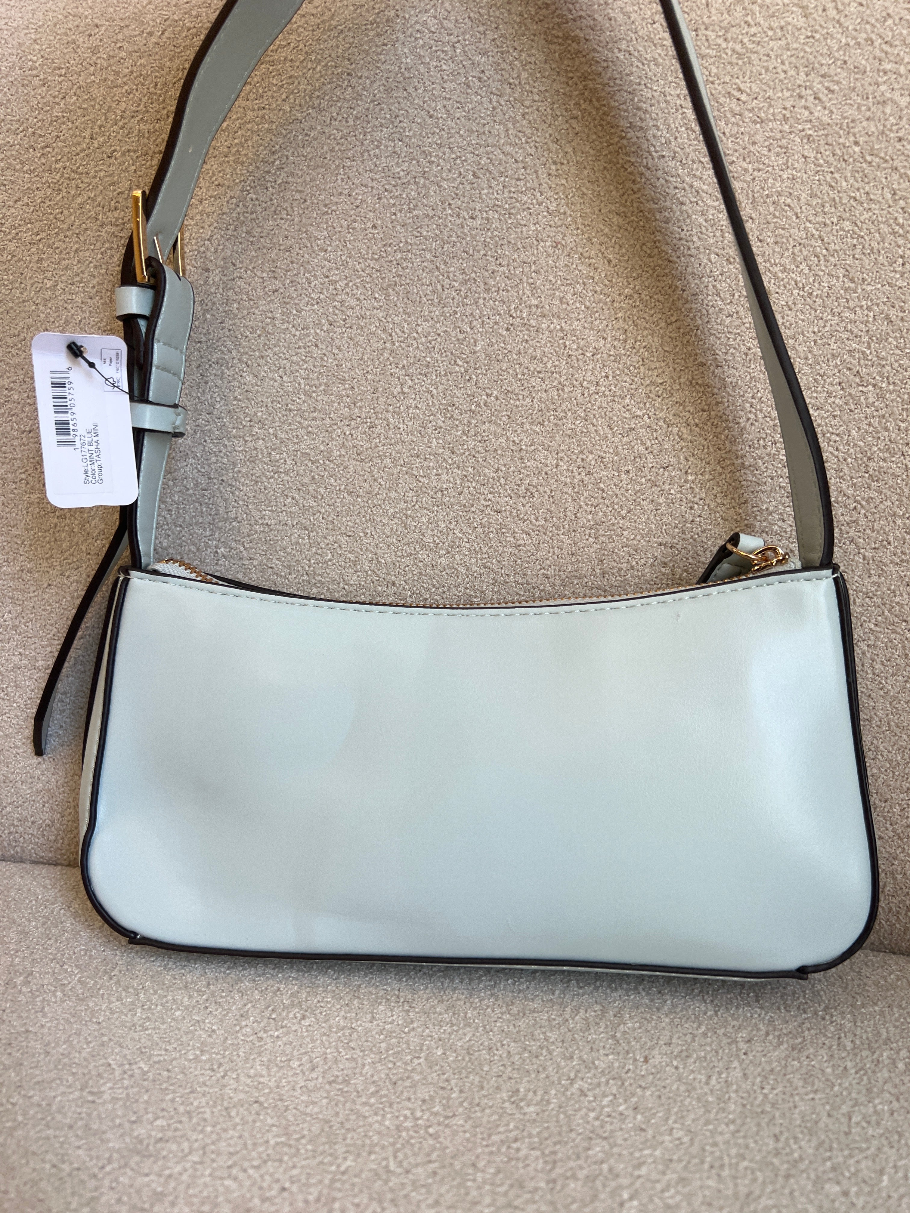 GUESS Tasha Mini Shoulder bag features a light blue synthetic exterior and a polished gold-tone triangular logo plaque