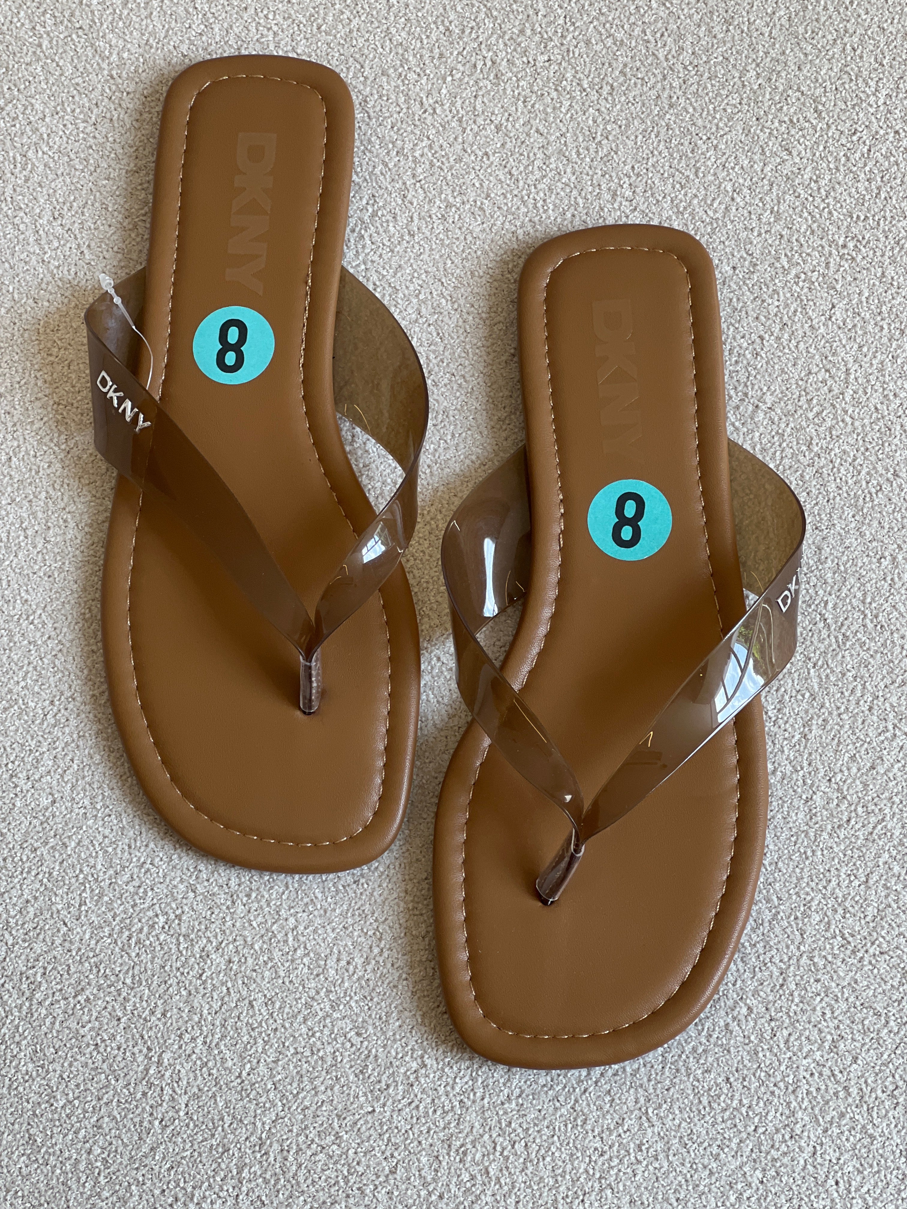 DKNY flip-flops featuring tan footbeds and clear straps