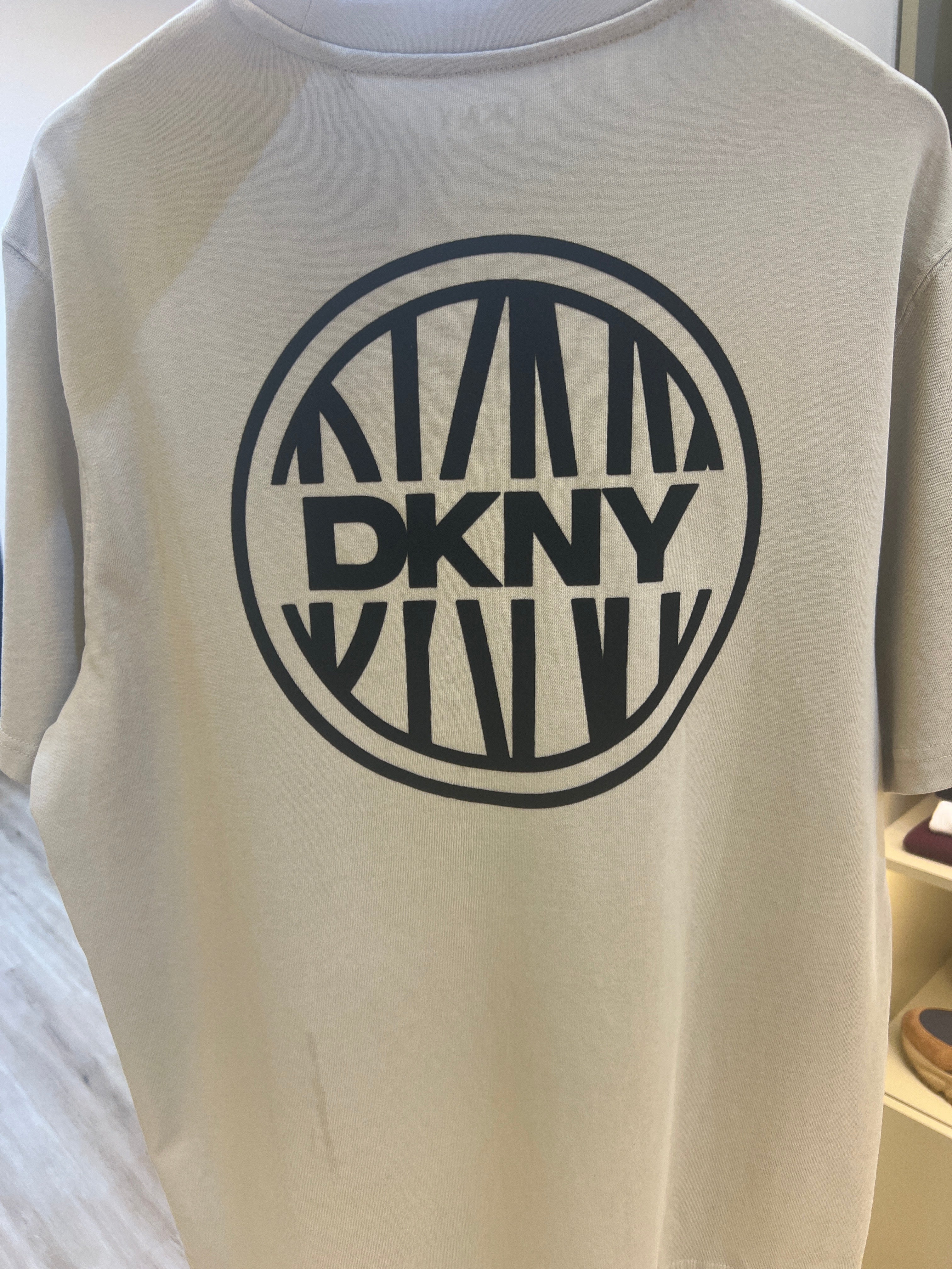 DKNY t-shirt, likely featuring a crew neck and short sleeves, is branded with a prominent "DKNY CIRCA 1989" logo on the chest and back print
