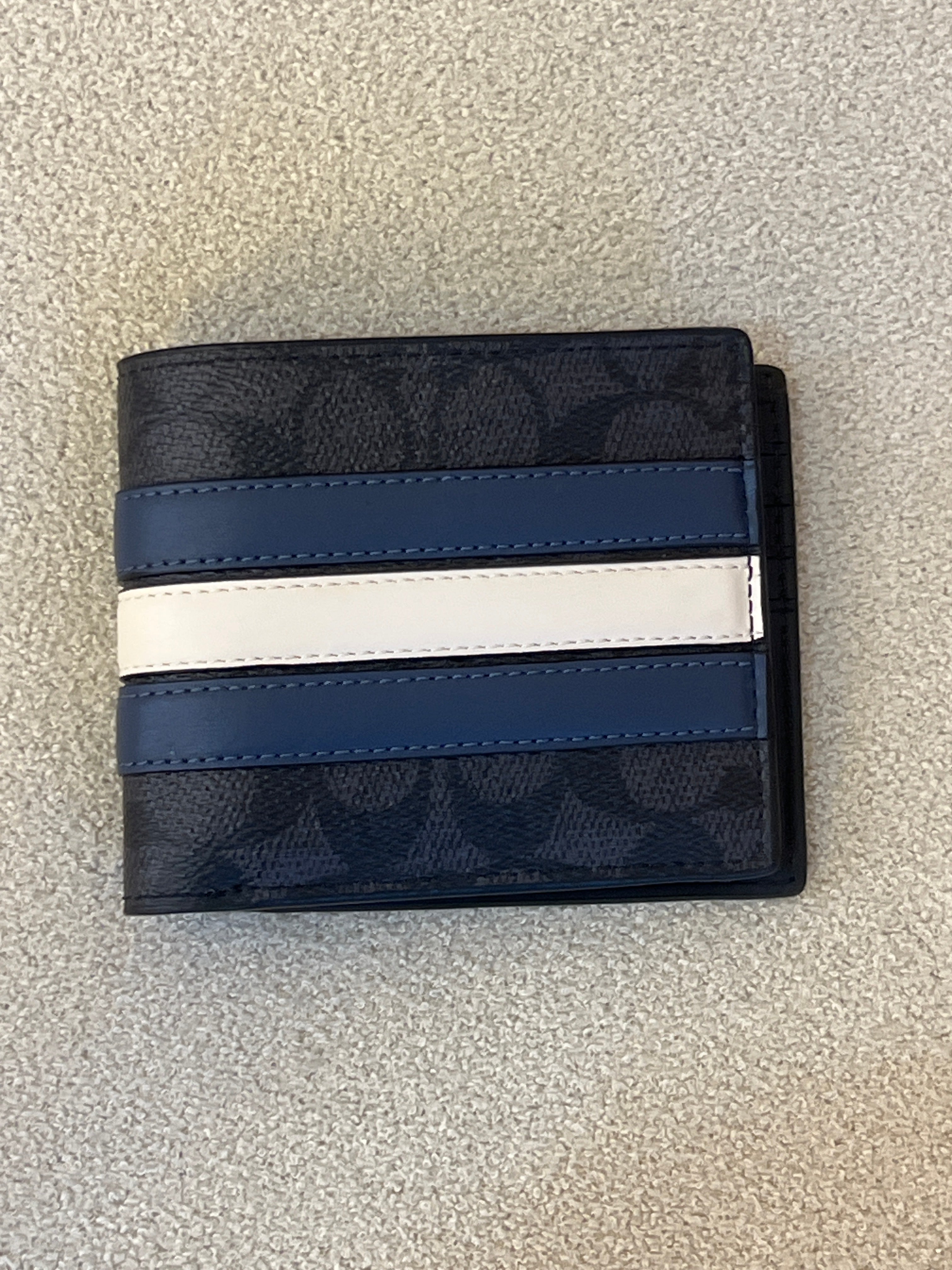Coach 3-In-1 wallet featuring a black signature canvas design accented with blue and white varsity stripes