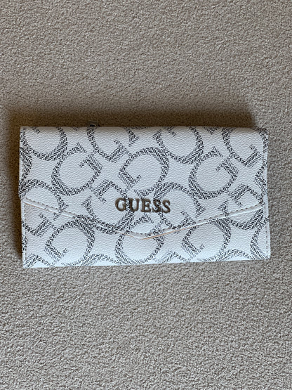 Guess Granby SLG Slim Clutch features an all-over logo print and a snap button closure