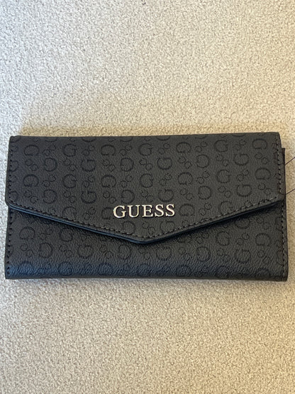 Guess clutch wallet featuring an all-over monogram logo print and a snap-flap closure