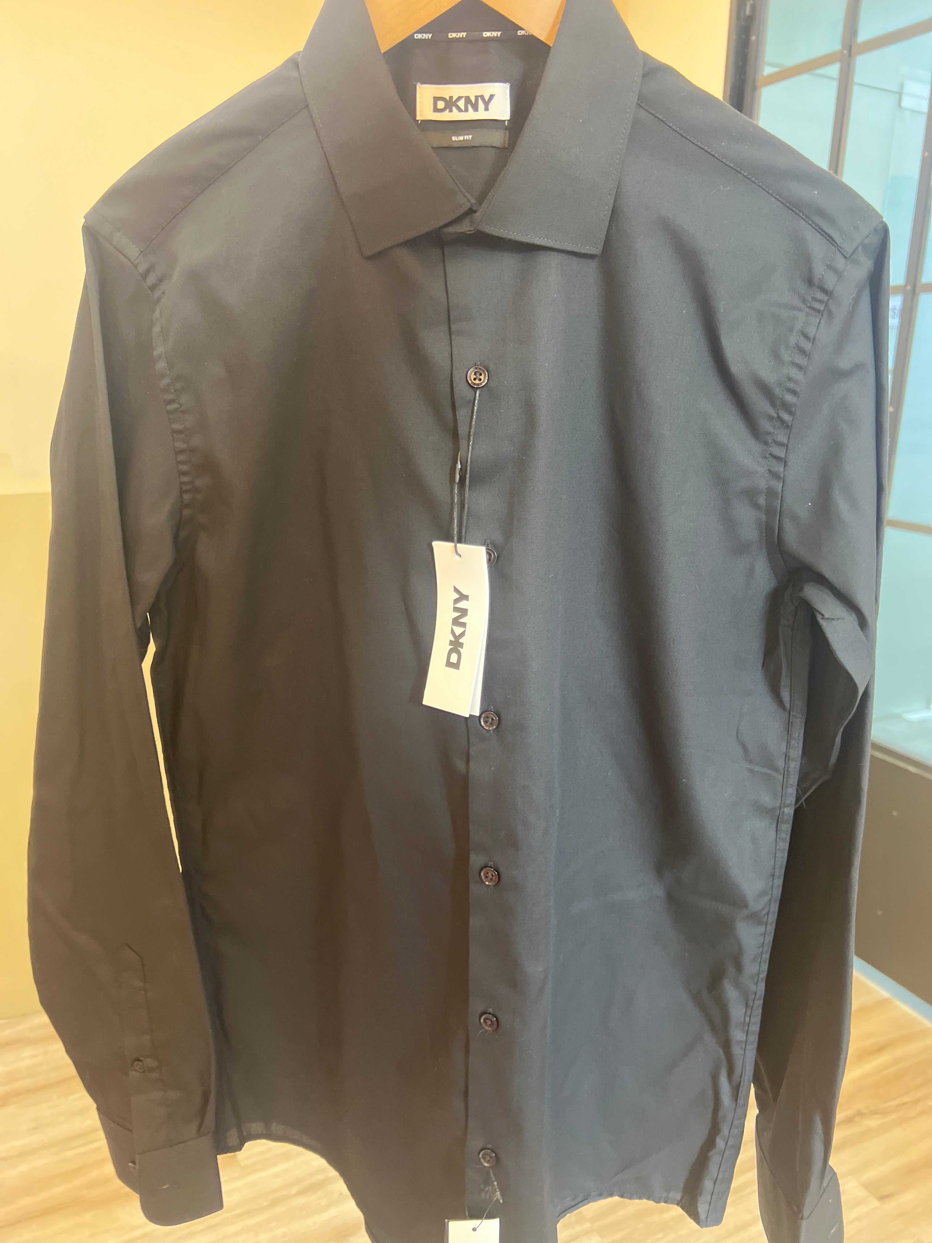 DKNY men's black dress shirt featuring a classic collar, front button fastening, and long sleeves