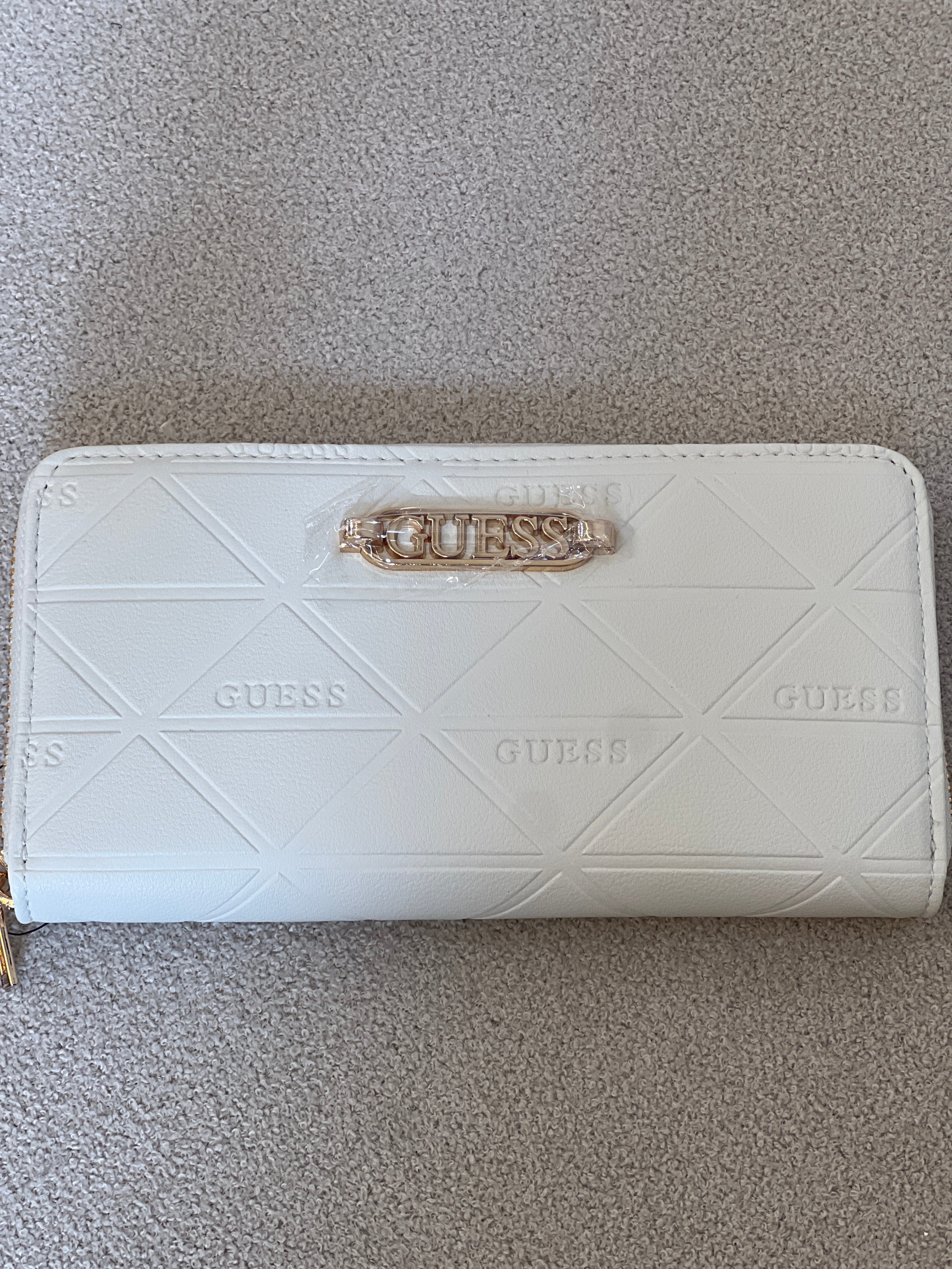 Guess wallet features a quilted triangular pattern and a prominent gold-toned brand logo on the front
