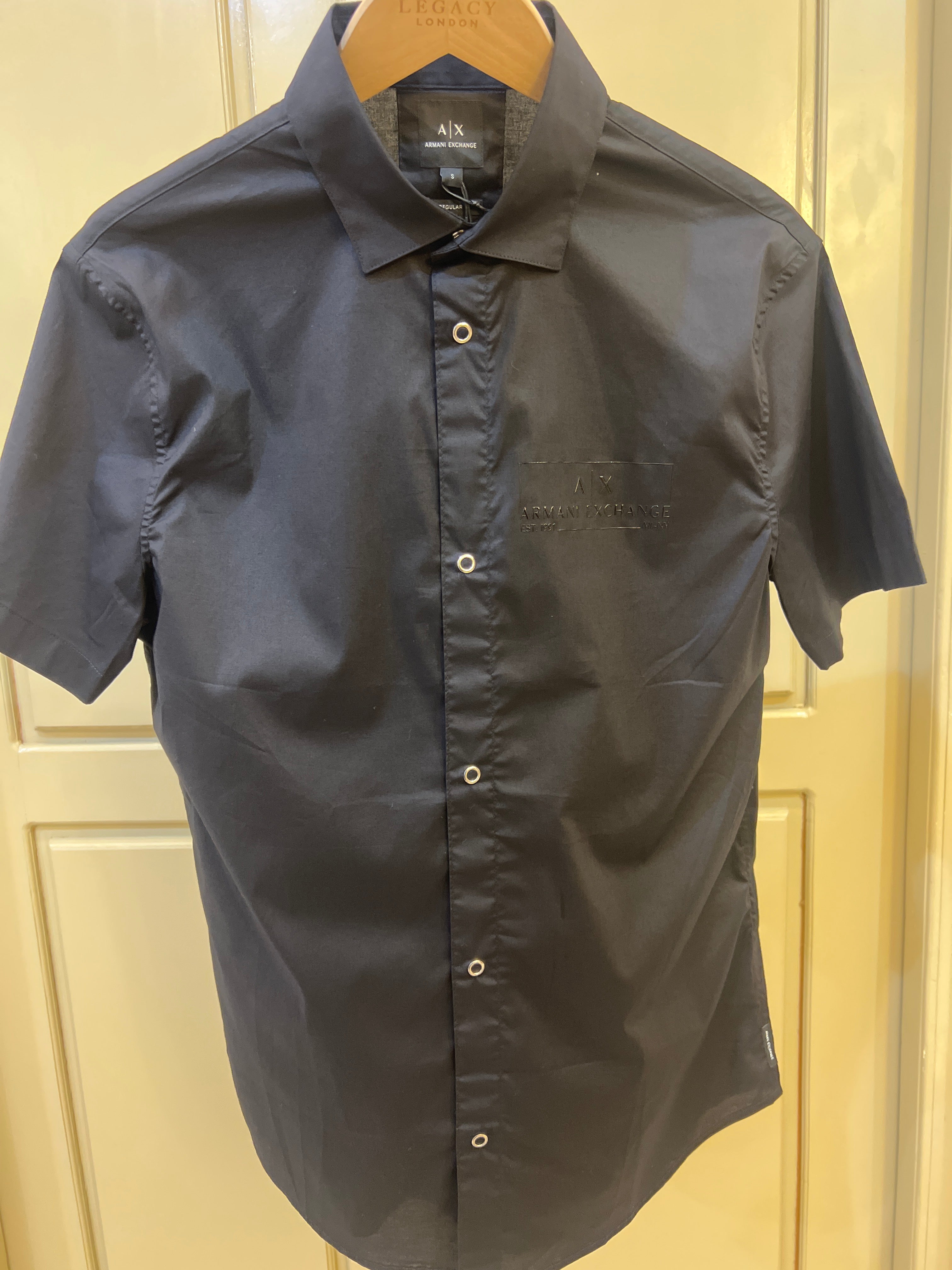 Armani Exchange short sleeve shirt features a sleek black design with metallic button detailing