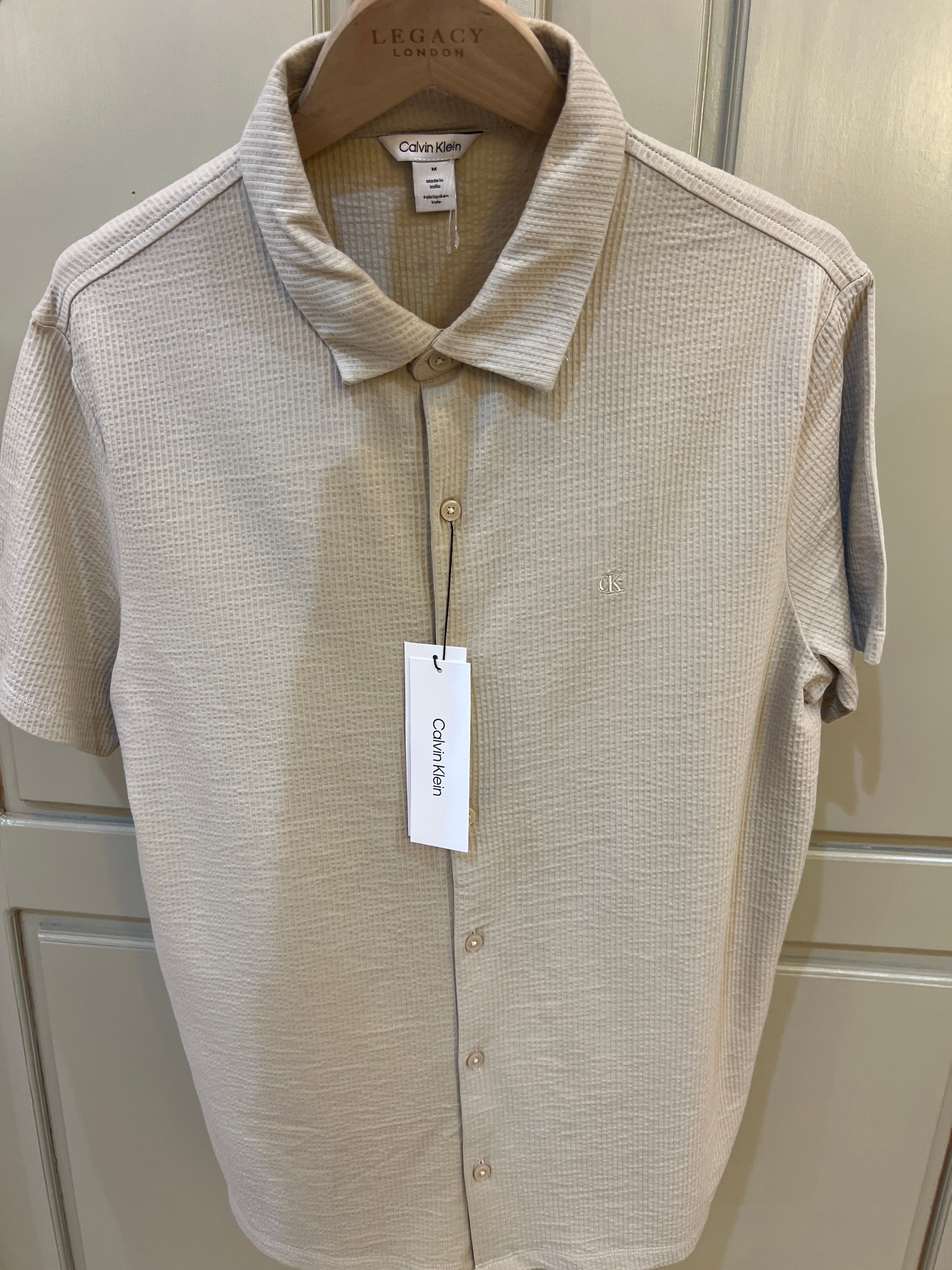 Calvin Klein short-sleeve button-down shirt features a textured fabric finish and subtle logo embroidery