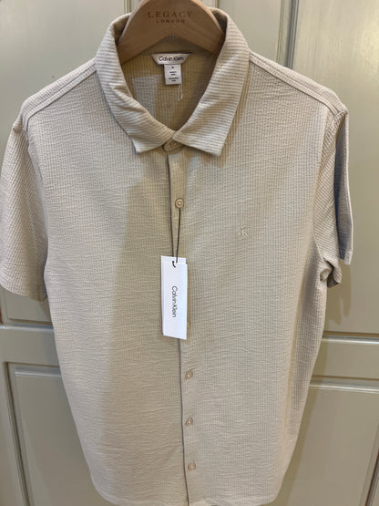 Calvin Klein short-sleeve button-down shirt features a textured fabric finish and subtle logo embroidery