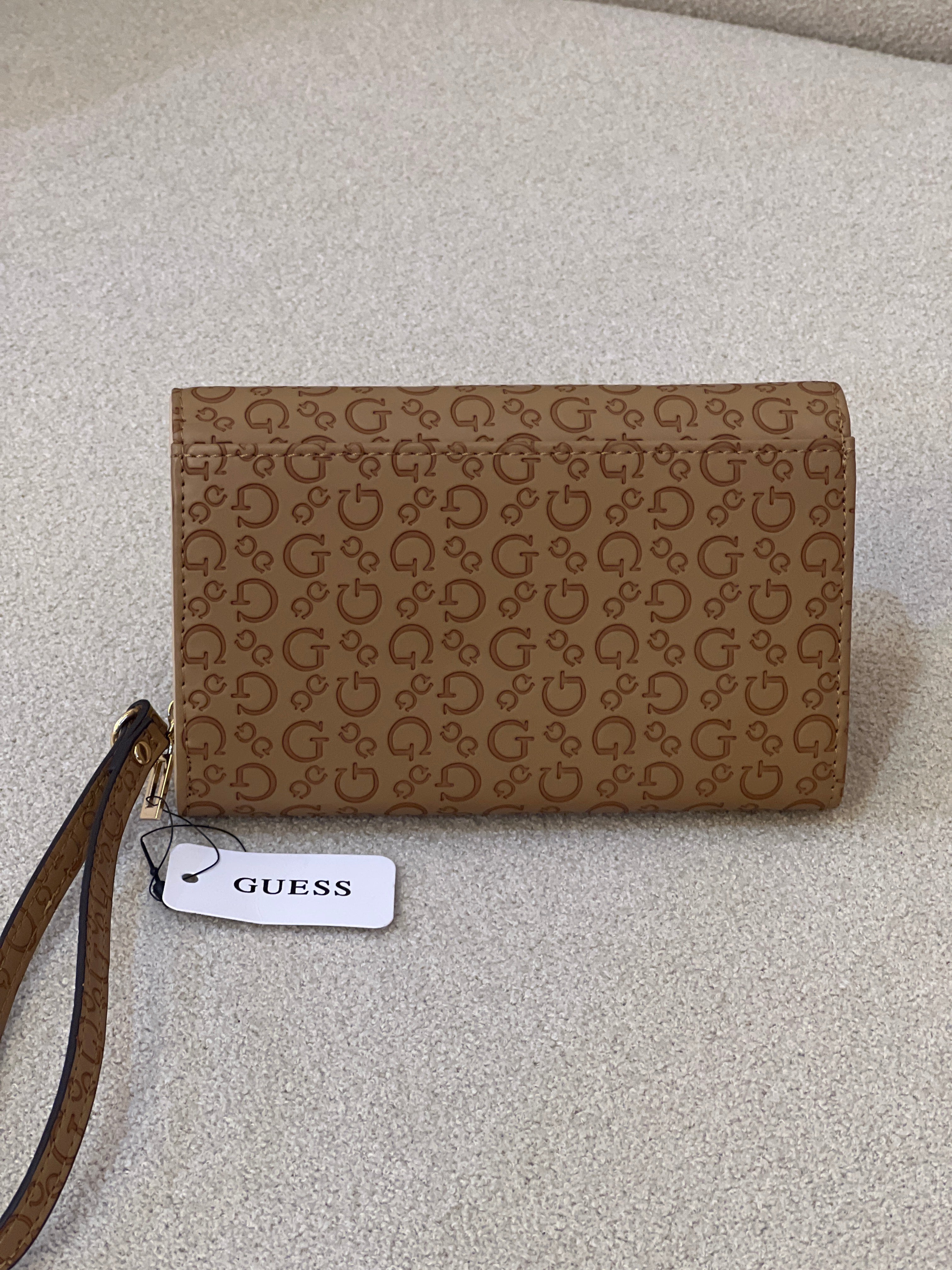Guess Julie Phone Organizer Wallet, a brown faux-leather wristlet featuring an allover logo print and a gold-tone triangle logo on the front