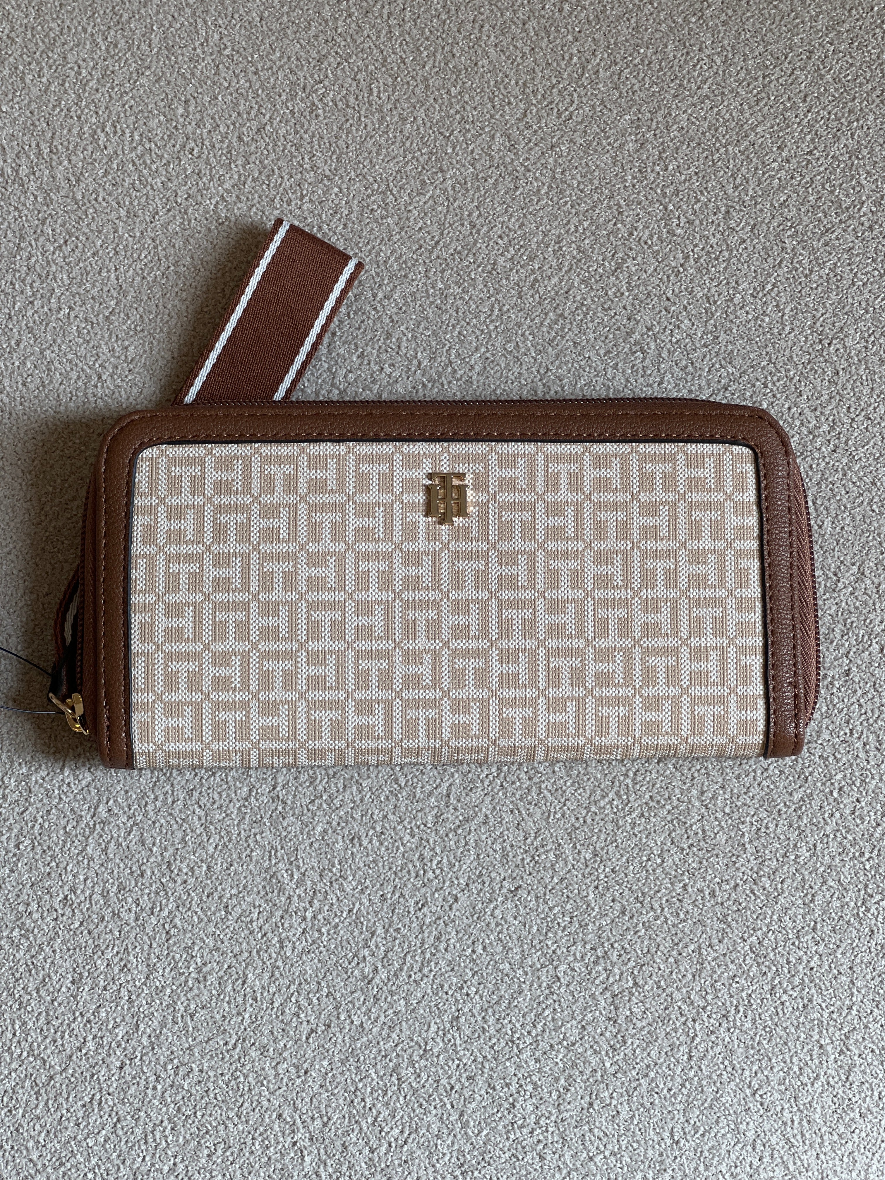 Tommy Hilfiger monogram jacquard zip-around wallet features a classic beige pattern with brown trim