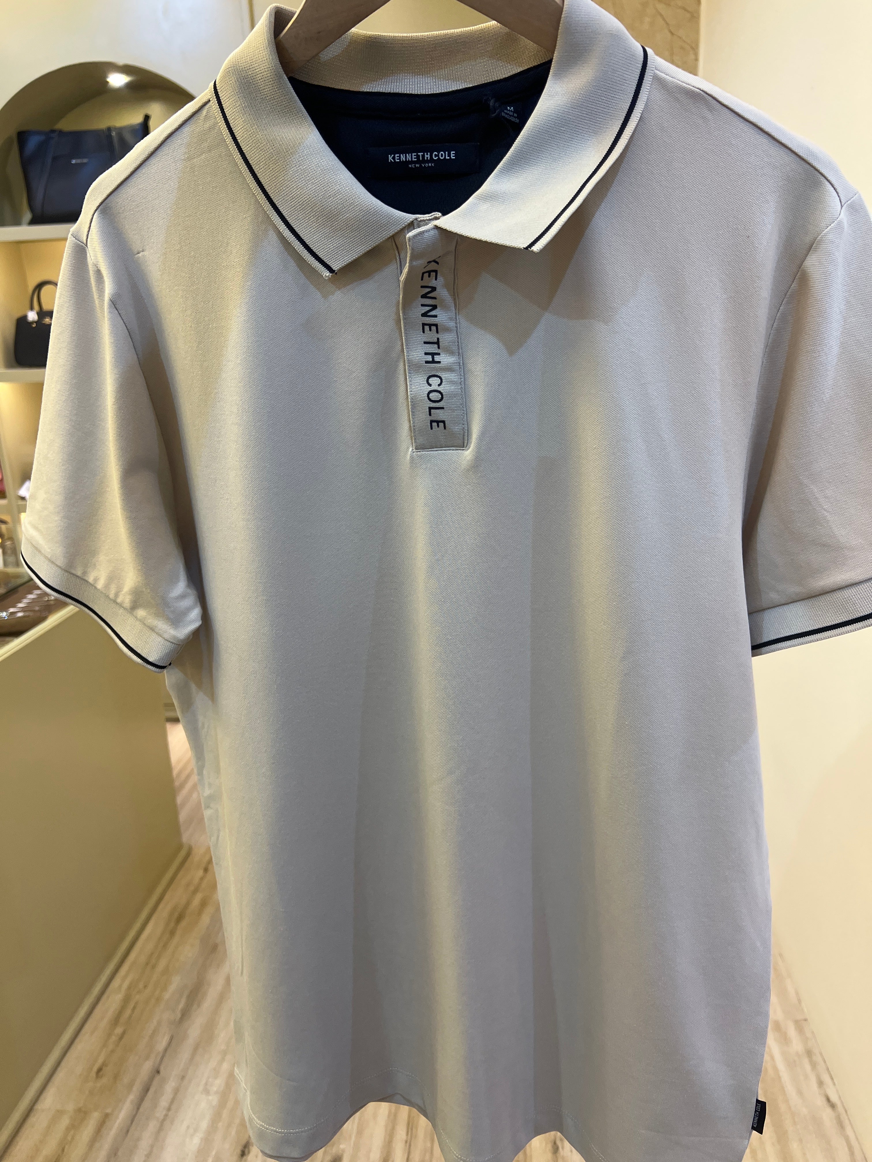 Kenneth Cole branded men's white polo shirt features a distinctive branded zip-placket and contrast tipping on the collar