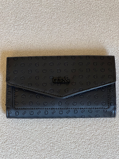 Guess monogram wallet features a distinctive embossed logo pattern and a snap closure