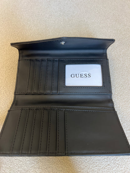 Guess monogram wallet features a distinctive embossed logo pattern and a snap closure