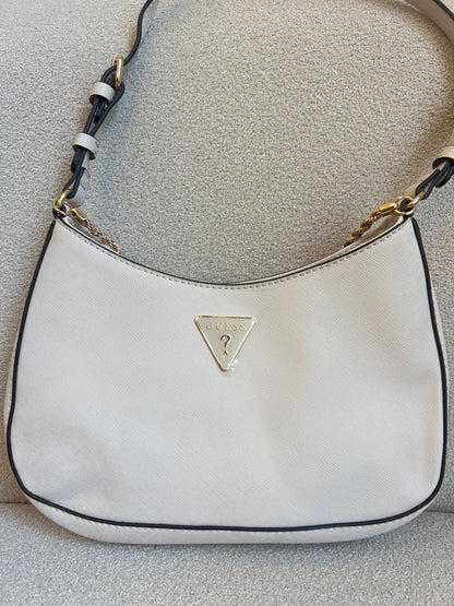 GUESS Noelle Saffiano Shoulder Bag in bone white features a gold-tone chain strap and a signature triangular logo plaque