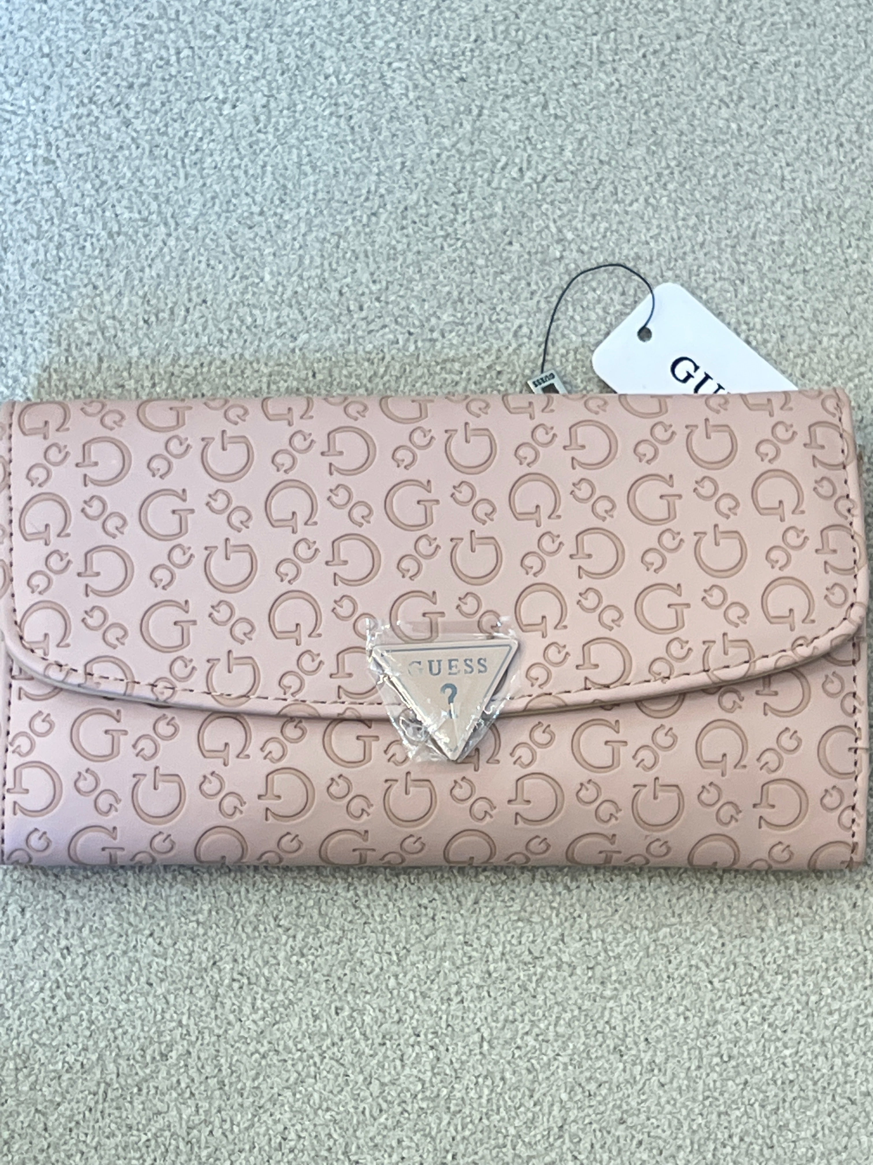 Guess Viviette tri-fold wallet features a textured, light pink monogram exterior and a prominent triangular logo plaque