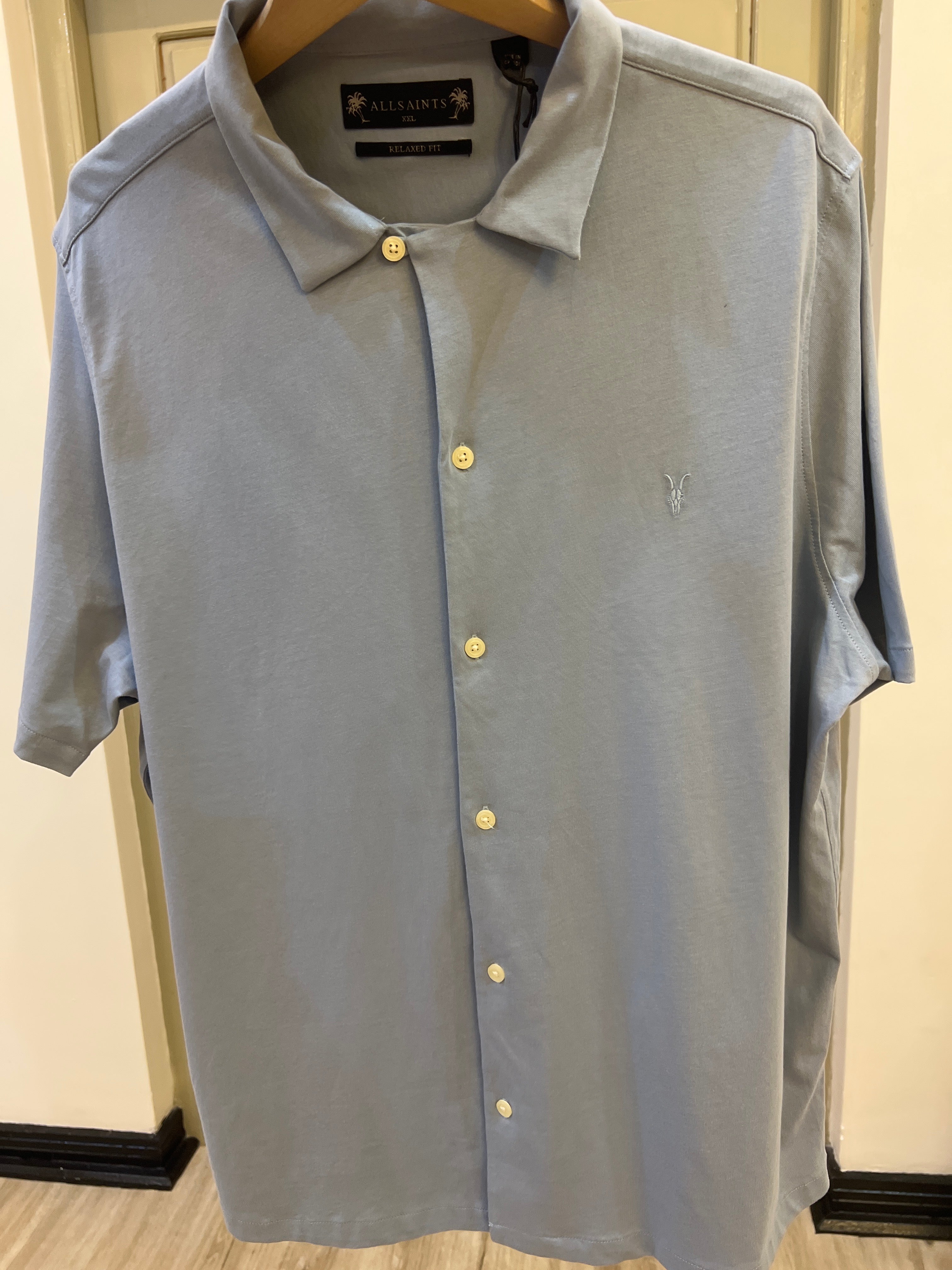 AllSaints men's light blue button-down shirt featuring the brand's signature embroidered logo on the chest
