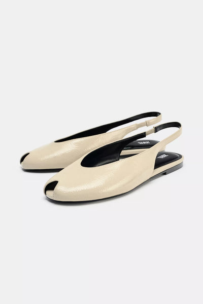 cream-colored Zara pointed-toe slingback flats feature a patent leather finish and an elasticated heel strap