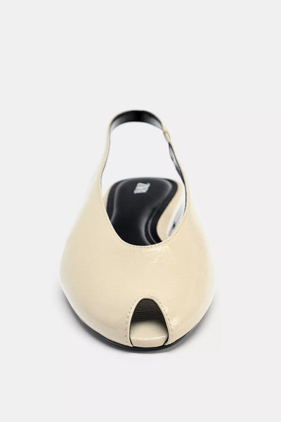 cream-colored Zara pointed-toe slingback flats feature a patent leather finish and an elasticated heel strap